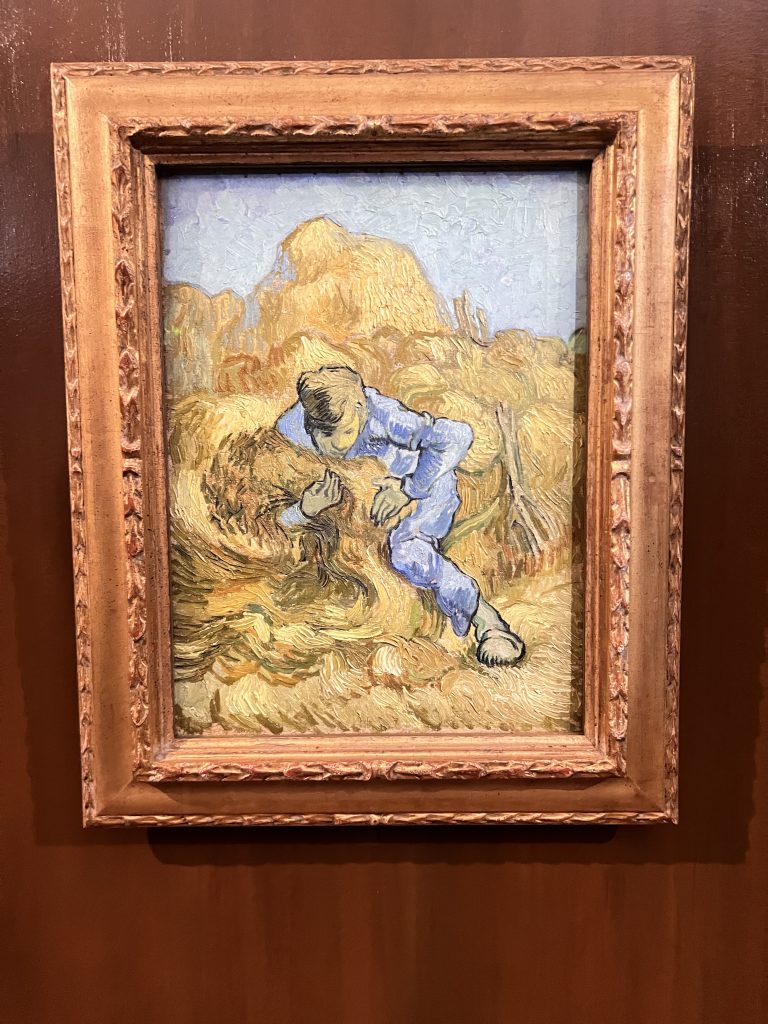 Gutsy Traveler: A framed painting beautifully captures the essence of a France river cruise for travelers 50+, with a person in blue clothing sitting serenely in a field surrounded by tall golden stalks, evoking the tranquil landscapes often admired on such journeys.