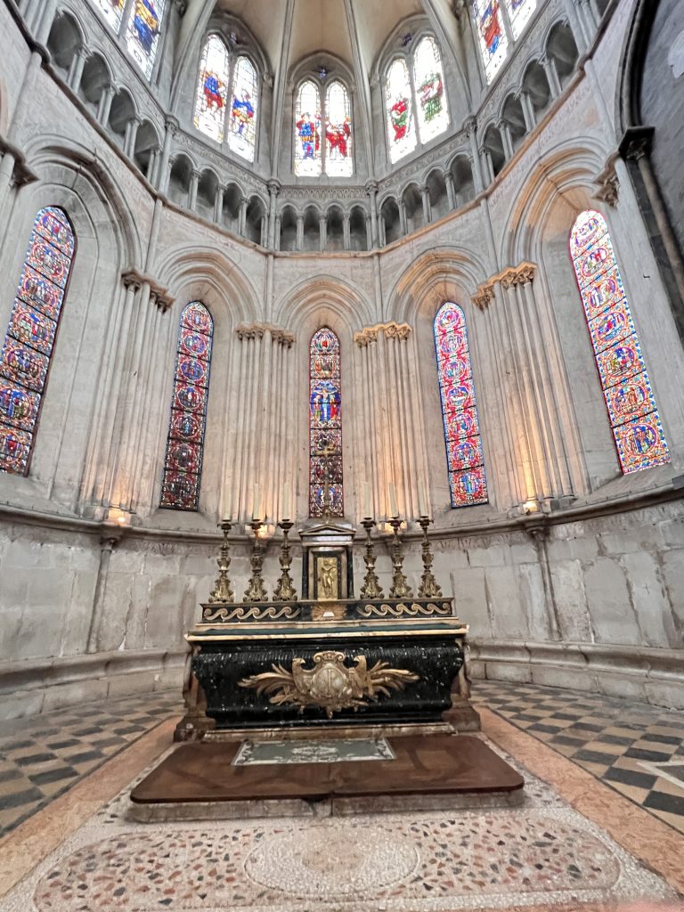 Gutsy Traveler: The ornate altar in the cathedral, with its tall stained glass windows and detailed stone architecture, rivals the breathtaking sights found on a France river cruise for travelers 50+, offering a serene voyage through history and art.