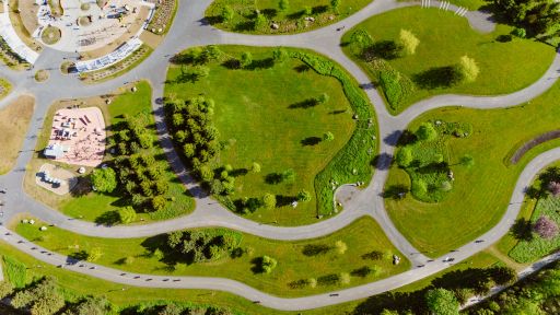 Gutsy Traveler: Aerial view of a park in Quebec City with winding paths, grassy areas, clusters of trees, and a playground in the upper left corner—perfect for any weekend guide of things to do.